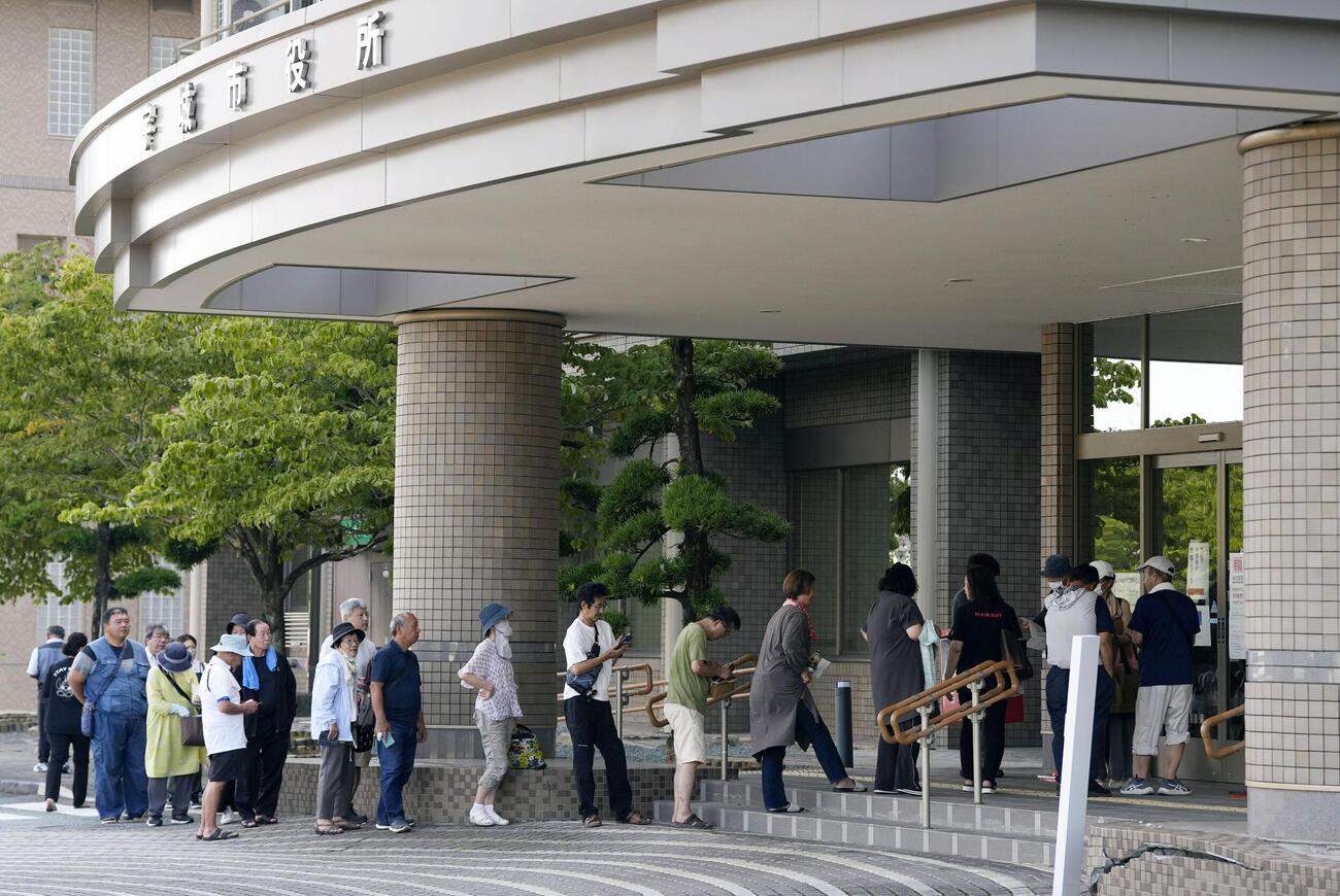 相談や手続きで熊本県宇城市役所を訪れ、始業を待つ人たち（共同）