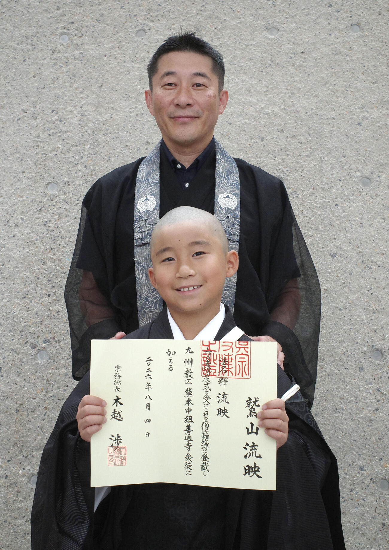 京都・東本願寺の「得度式」に参加した熊本県美里町の善通寺住職鷲山利生さん（奥）と三男流映さん（共同）