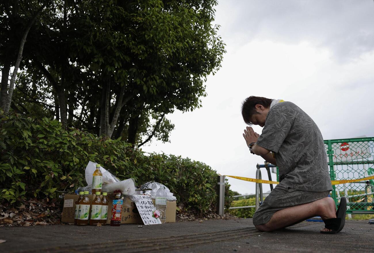 爆発で犠牲者が出た「イオンモール熊本」付近で手を合わせる男性＝4日午後、熊本県嘉島町（共同）