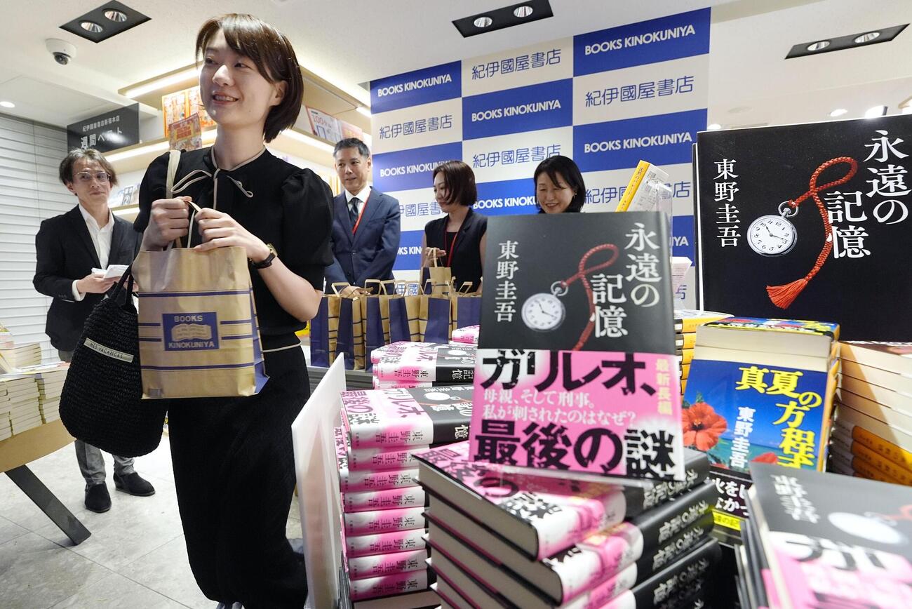 紀伊国屋書店新宿本店で、東野圭吾さんの新刊小説を受け取る女性＝5日未明、東京都新宿区（共同）