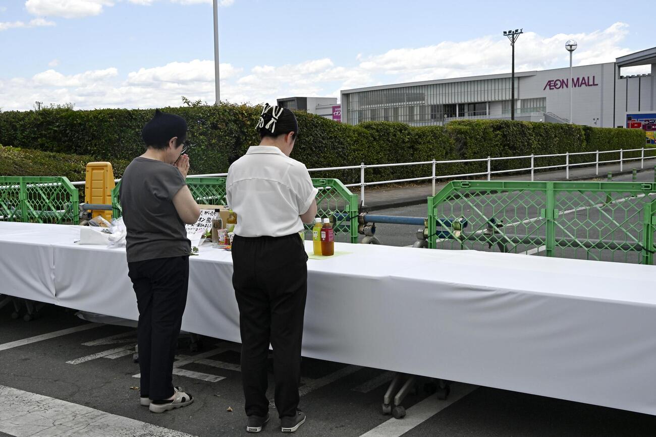 爆発の起きた「イオンモール熊本」に設置された献花台で手を合わせる人＝5日午後、熊本県嘉島町（共同）