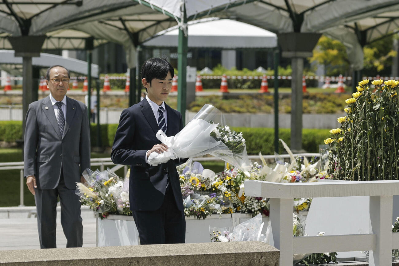 広島市の平和記念公園で原爆慰霊碑に供花される悠仁さま。左は松井一実市長（共同）