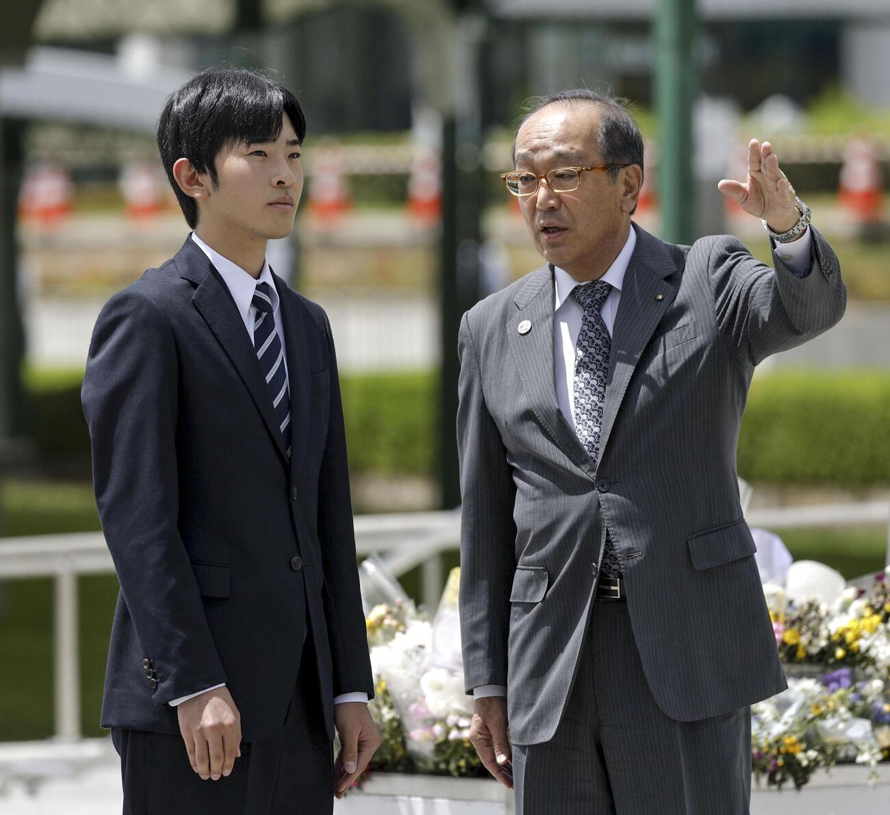 広島市の平和記念公園で原爆慰霊碑に供花し、松井一実市長（右）から説明を受けられる悠仁さま（共同）