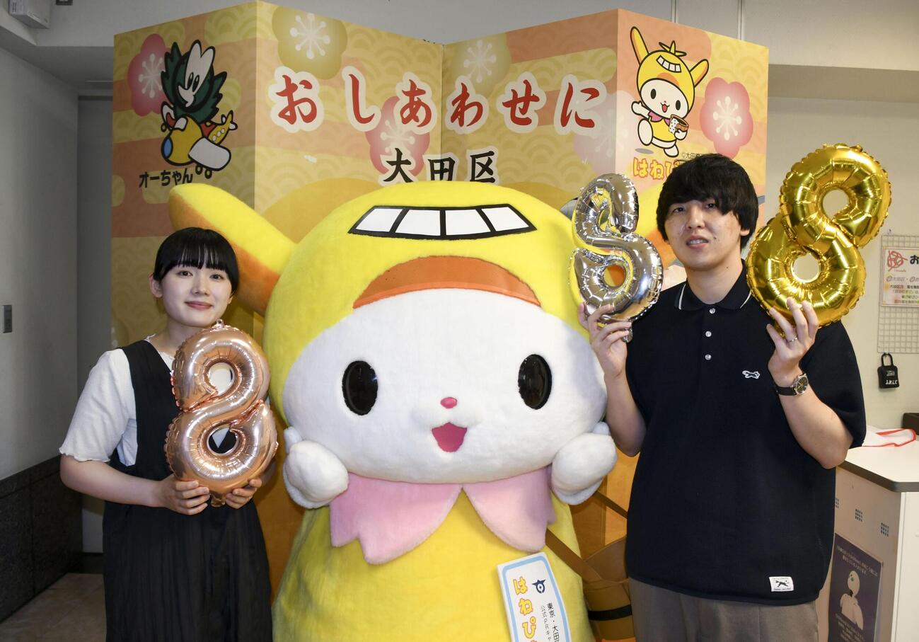 東京都大田区役所に婚姻届を提出し、写真に納まるカップル＝8日午後（共同）