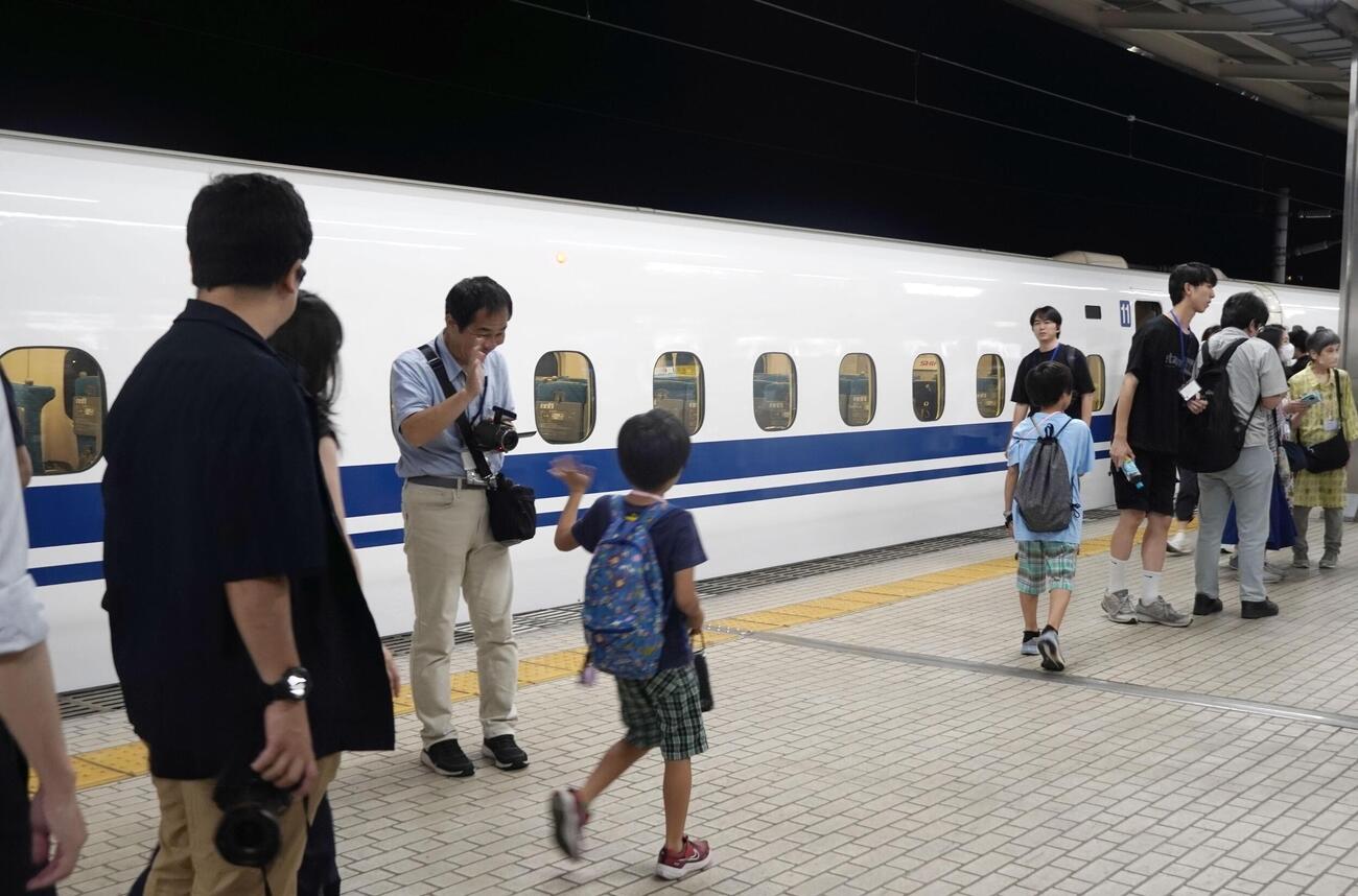 JR岐阜羽島駅に停車する東海道新幹線の特別列車「東海道ルミエールエクスプレス」とホームに降りる乗客＝8日深夜(共同)