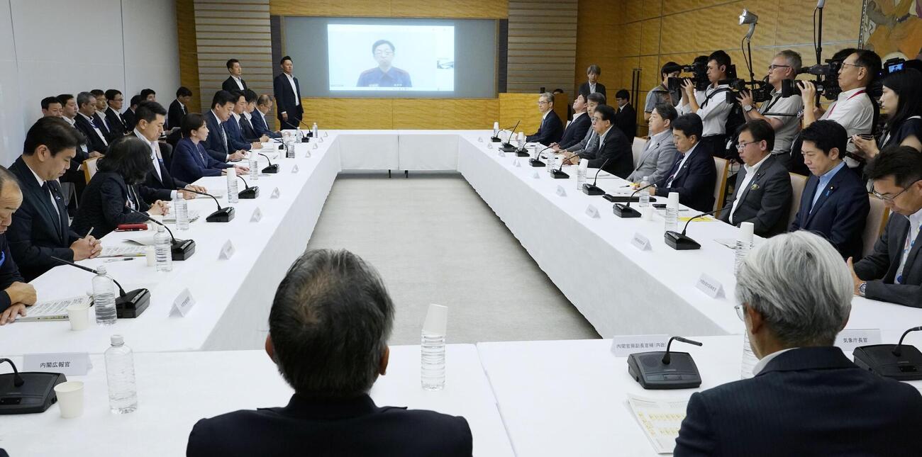首相官邸で開かれた非常災害対策本部会議。スクリーンはオンラインで参加した熊本県の木村敬知事（共同）