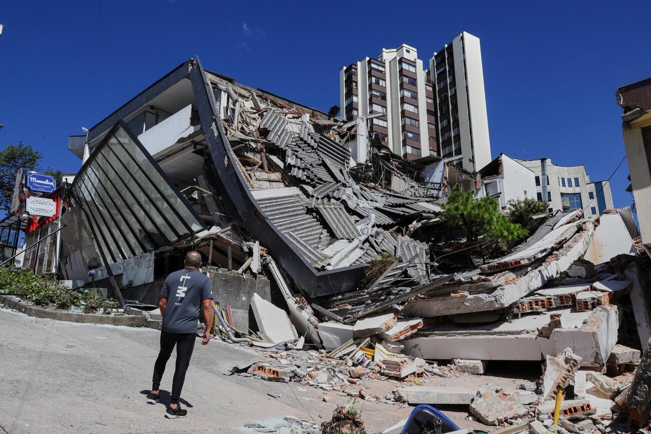 地震で倒壊した建物を見つめる男性＝10日、コロンビア中部マニサレス（AP＝共同）