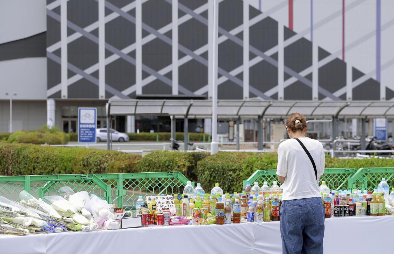 爆発の起きた「イオンモール熊本」に設置された献花台で手を合わせる人＝10日午前、熊本県嘉島町（共同）