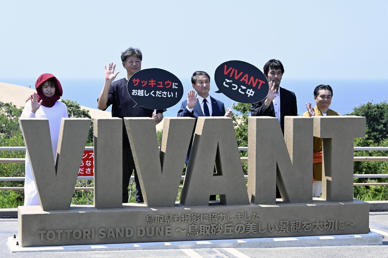 鳥取砂丘駐車場に設置された「VIVANT」のロゴモニュメントと平井伸治知事（中央）ら＝7月（共同）