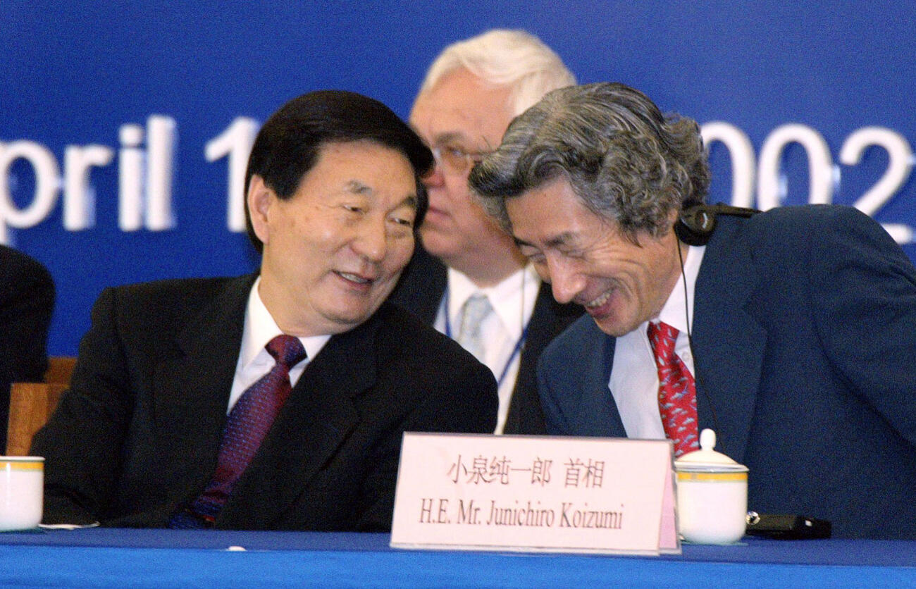 2002年4月、中国・海南島で開かれたアジアフォーラム第1回年次総会の全体会合で談笑する中国の朱鎔基首相（左）と小泉首相（共同）