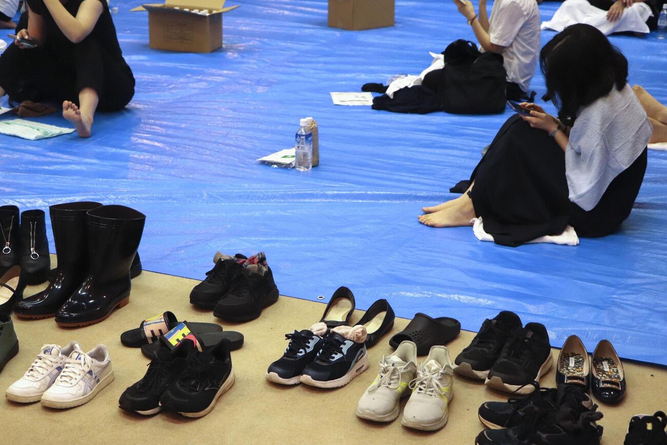 帰宅困難者向けに開放された千葉県庁の一時滞在場所に身を寄せる人たち＝13日午後8時38分（共同）