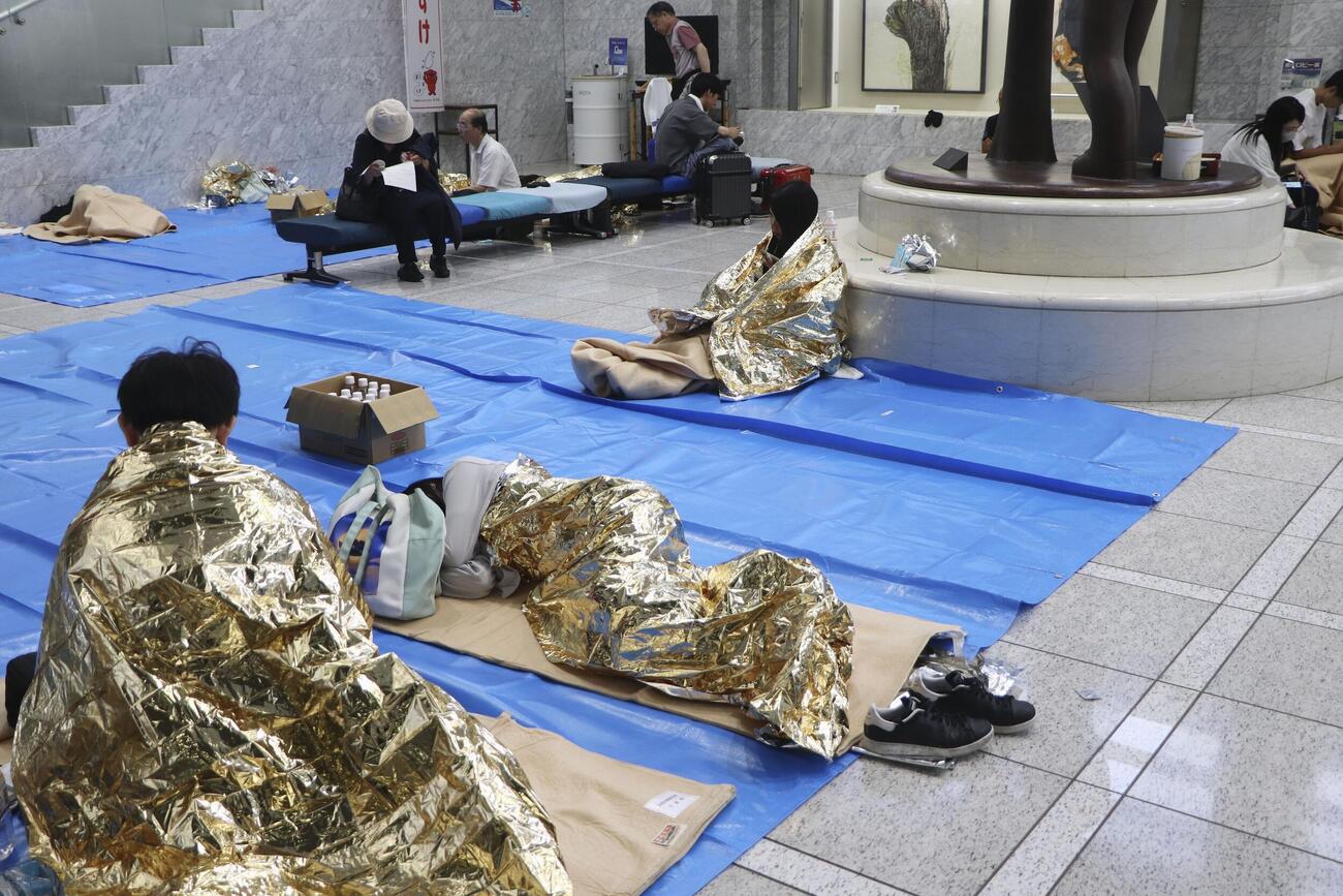 帰宅困難者向けに開放された千葉県庁に身を寄せる人たち＝14日午前7時8分、千葉市中央区