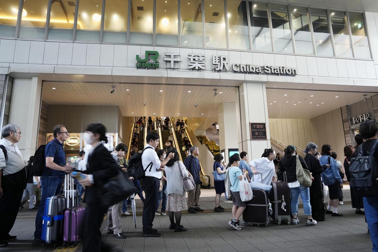 大雨から一夜明け、JR千葉駅前でバスなどを待つ人たち＝14日午前7時45分