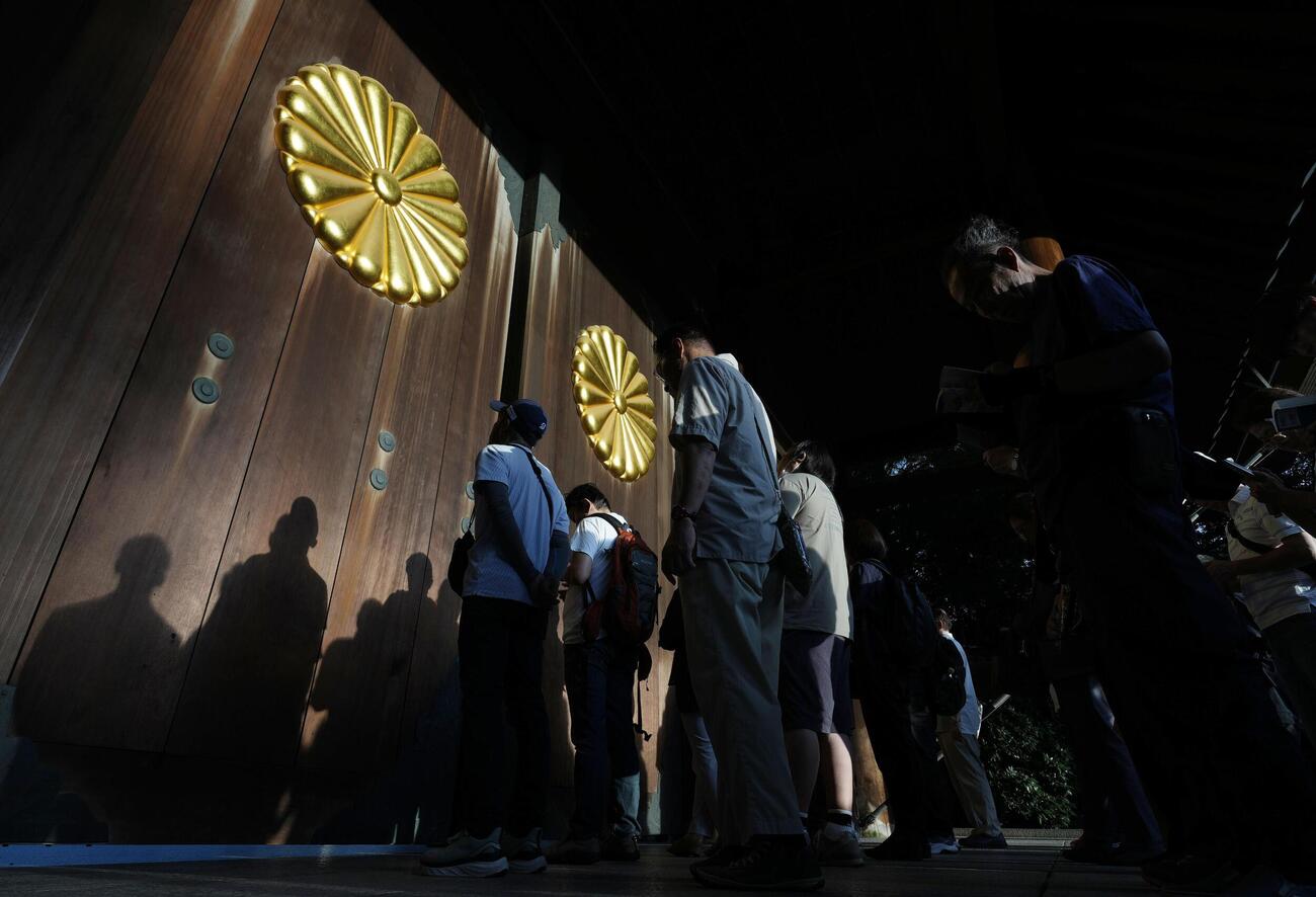 早朝から靖国神社を訪れ、開門を待つ人たち（共同）