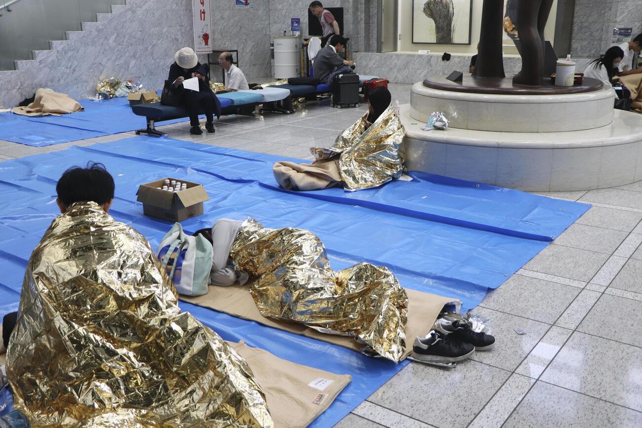 14日、帰宅困難者向けに開放された千葉県庁に身を寄せる人たち（共同）