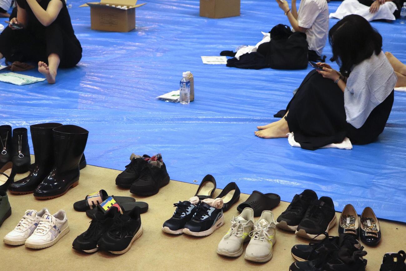 13日、帰宅困難者向けに開放された千葉県庁の一時滞在場所に身を寄せる人たち（共同）