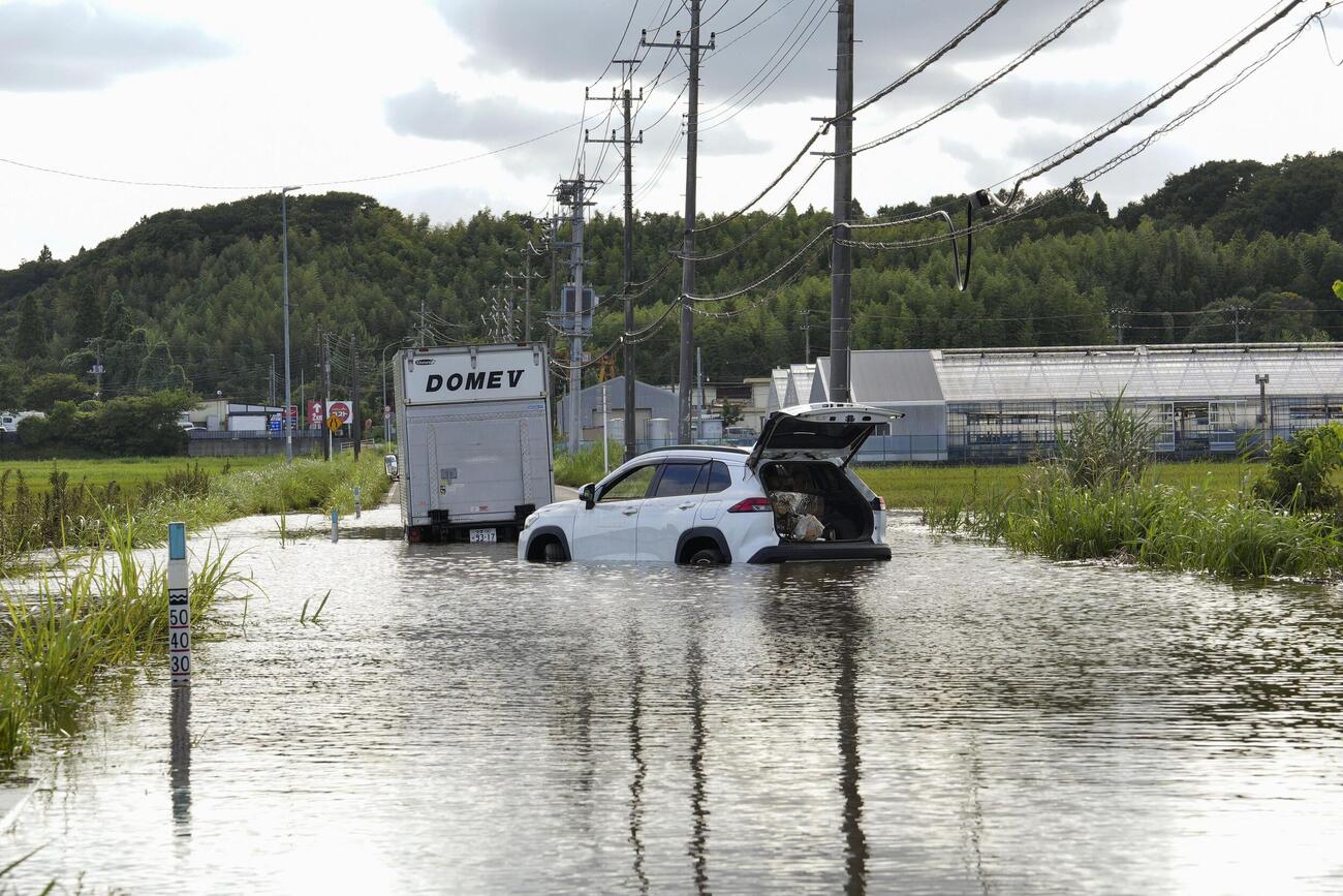 冠水した道路に放置されている車両＝15日午後、千葉県佐倉市(共同)