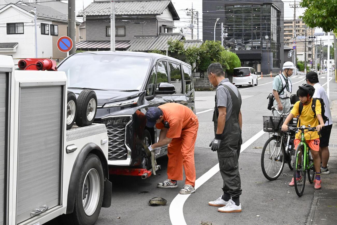 豪雨の影響で動かなくなった車の撤去作業(共同)