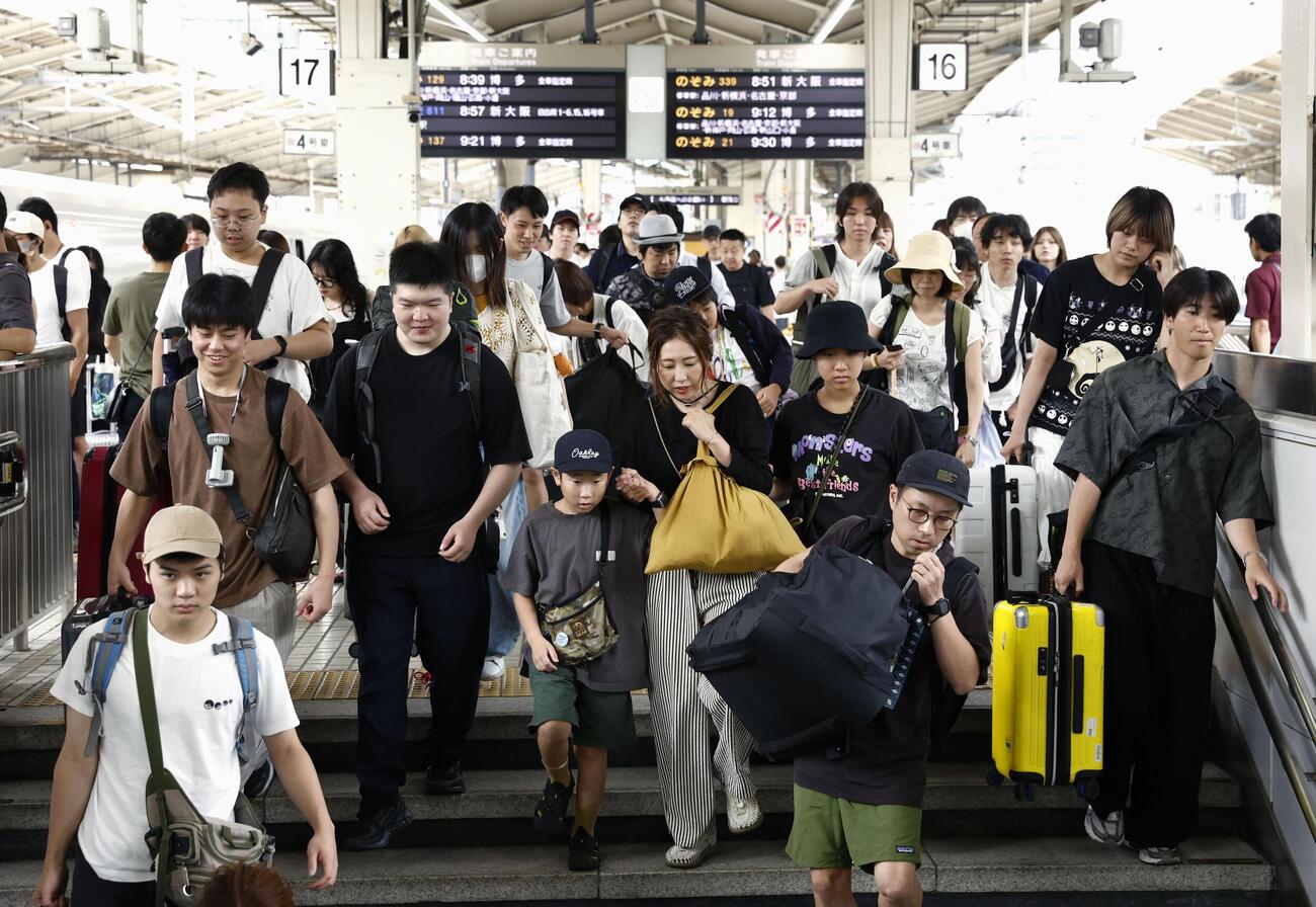 お盆休みの最終日となり、旅行や帰省先から帰る人たちのUターンラッシュで混雑するJR東京駅の新幹線ホーム（共同）