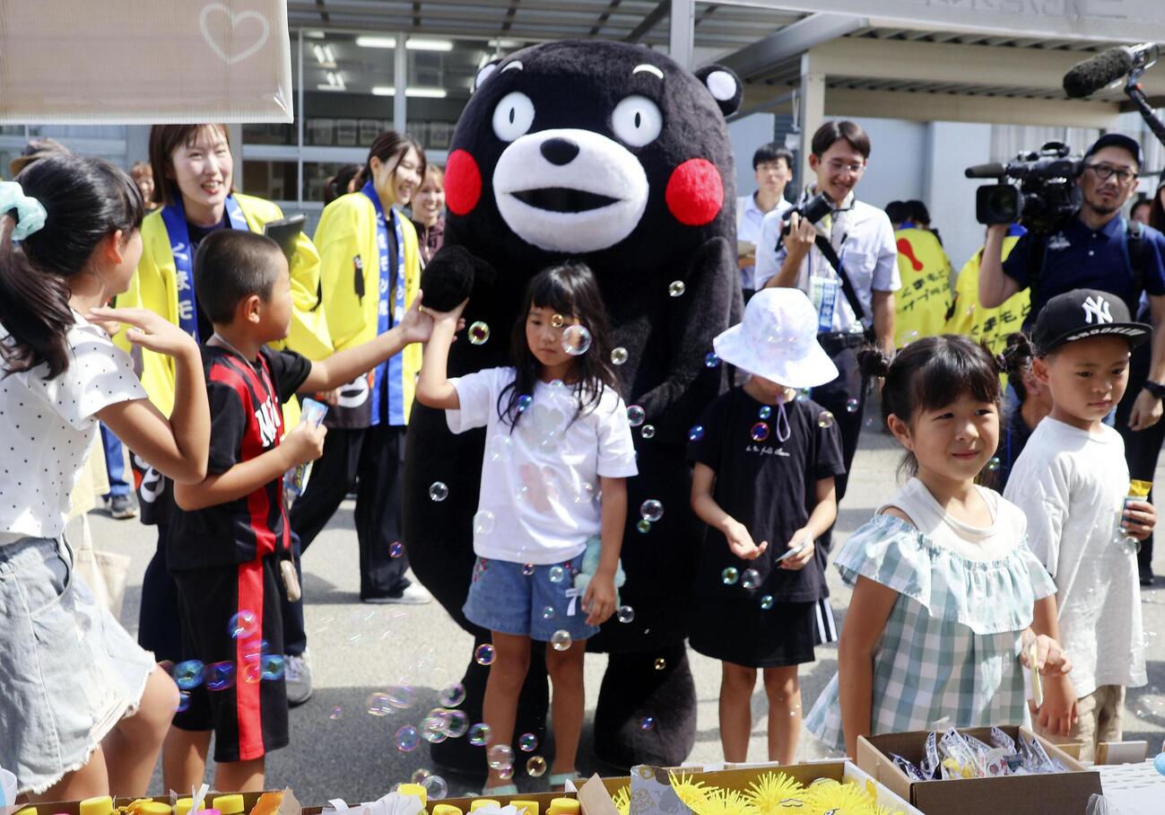 避難所となっている小学校で子供たちと交流する「くまモン」＝16日午前、熊本県氷川町(共同)