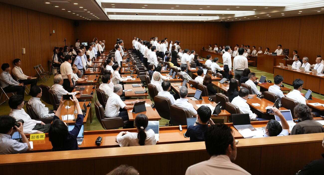 蔵内勇夫議長への辞職勧告決議案の採決を中止する動議に賛成し、起立する議員ら＝17日午後（共同）