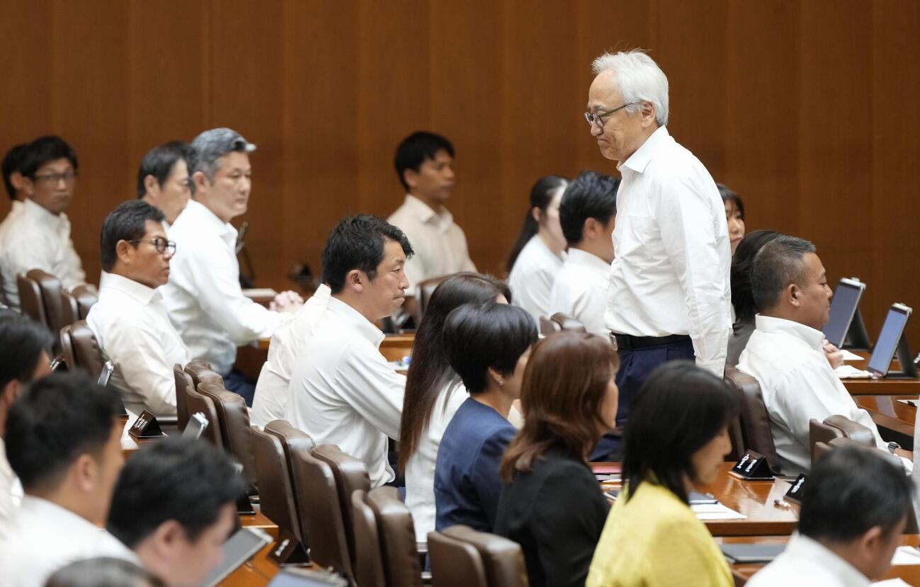 自身への辞職勧告決議案の採決前に、議場を後にする福岡県議会の蔵内勇夫議長。この後、動議が出され採決は中止された＝17日午後（共同）