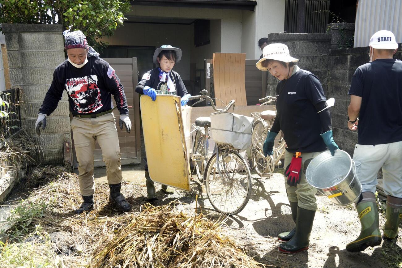 千葉県大網白里市で作業をするボランティアの人たち＝18日午前（共同）