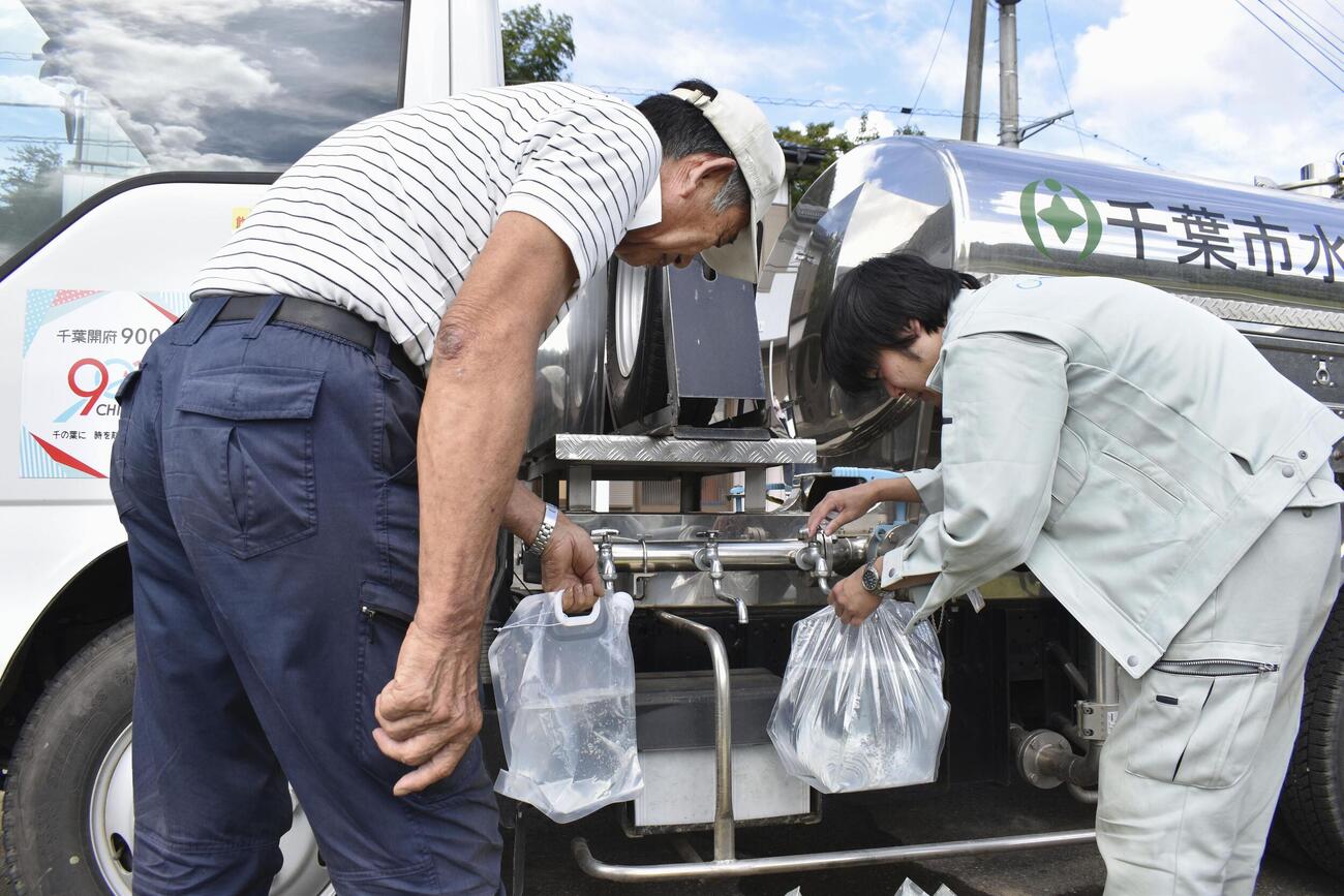 断水が続く千葉市緑区小食土町で、給水車から水を容器に入れる地元住民ら（共同）