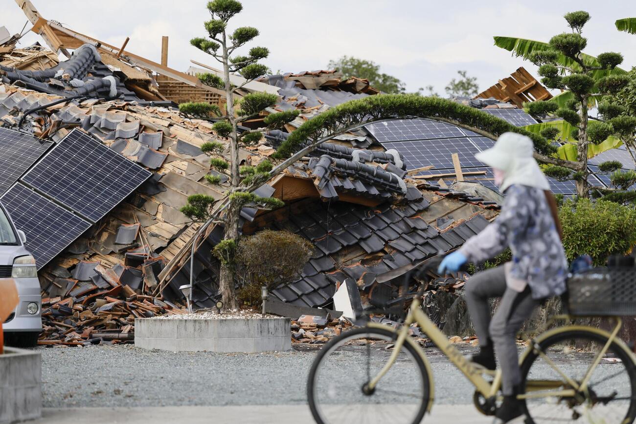 最大震度7を観測した地震から3週間となった熊本県氷川町で倒壊したまま残る家屋（共同）