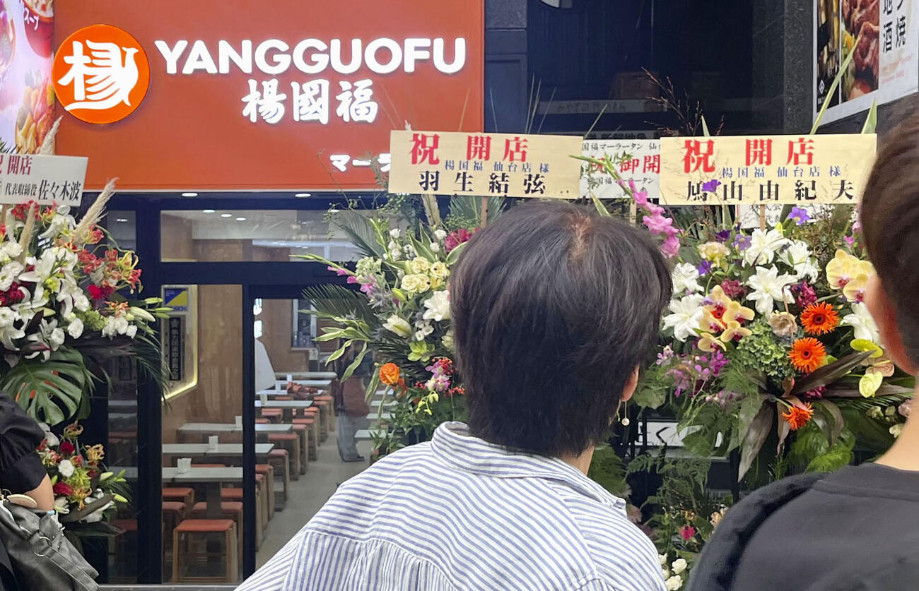 「楊国福麻辣湯仙台駅前店」前に置かれた祝い花。プロフィギュアスケーター羽生結弦さんと鳩山由紀夫元首相の名前が掲げられていた＝17日、仙台市（提供写真、共同）