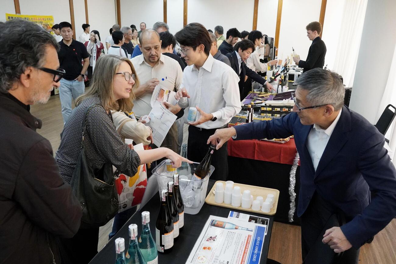 新潟県の日本酒の試飲コーナーに集まる来場者（共同）