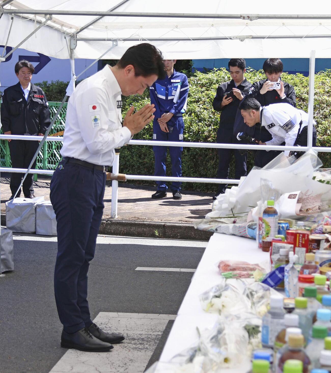 地震後に爆発が起きた「イオンモール熊本」で献花し手を合わせる小泉防衛相＝23日午前、熊本県嘉島町(共同)