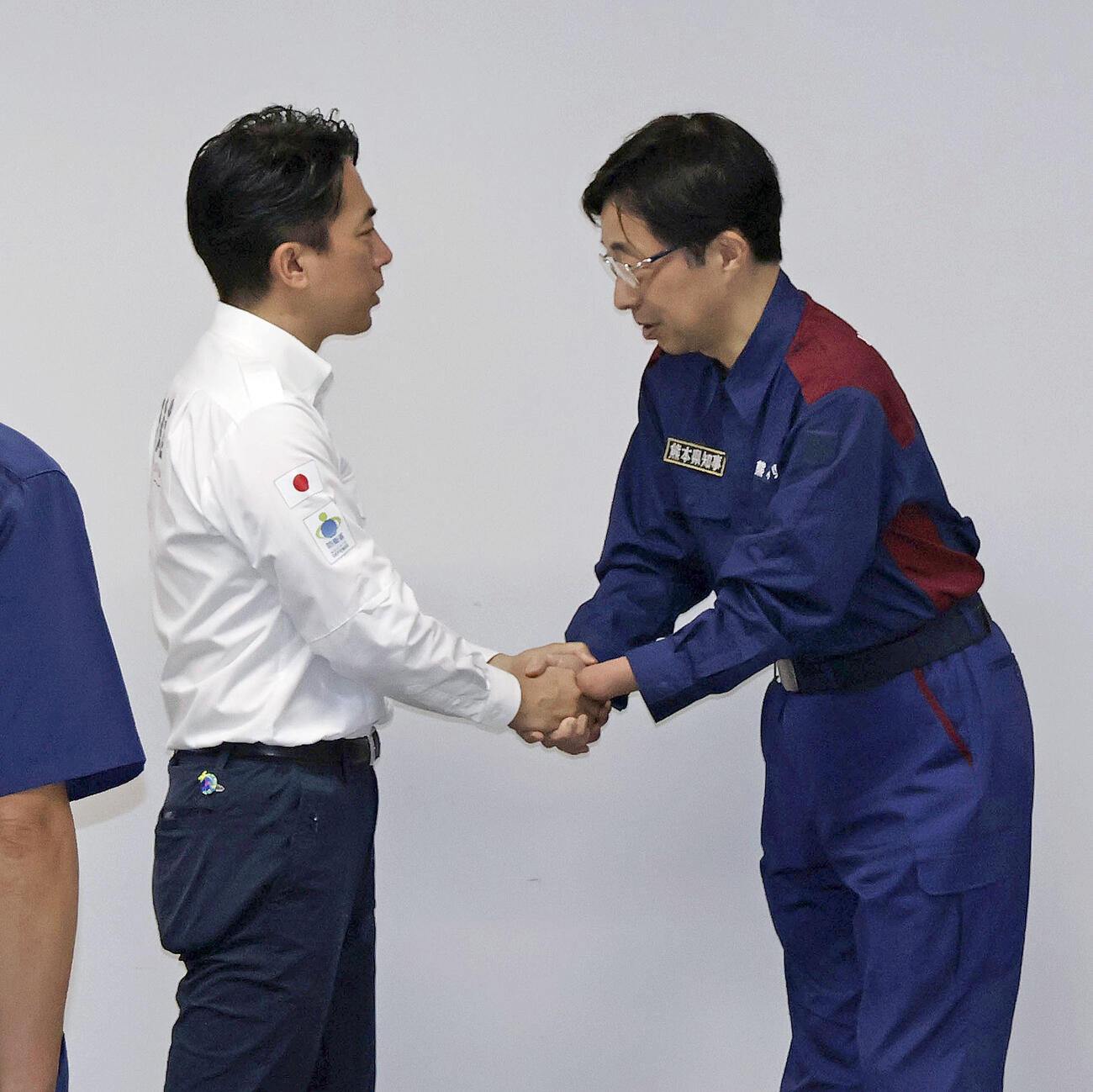 熊本県の木村敬知事（右）と面会し握手する小泉防衛相＝23日午後、熊本県庁(共同)