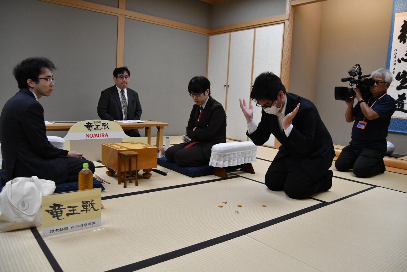 先手後手を決める振り駒は歩が4枚で服部慎一郎七段（中央）が先手、柵木幹太五段（左）が後手