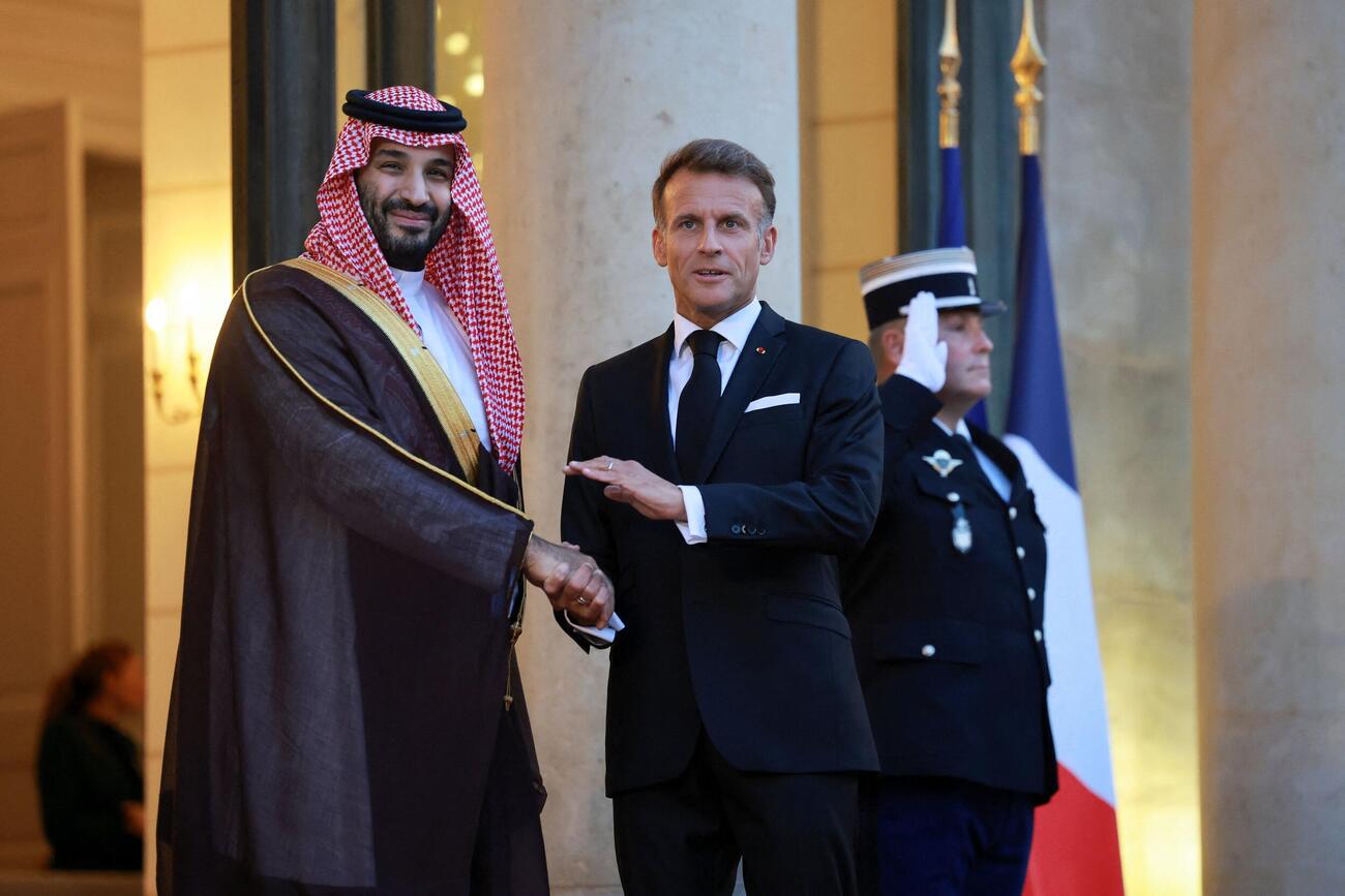 サウジアラビアのムハンマド皇太子（左）と握手するフランスのマクロン大統領＝パリ（ロイター＝共同）