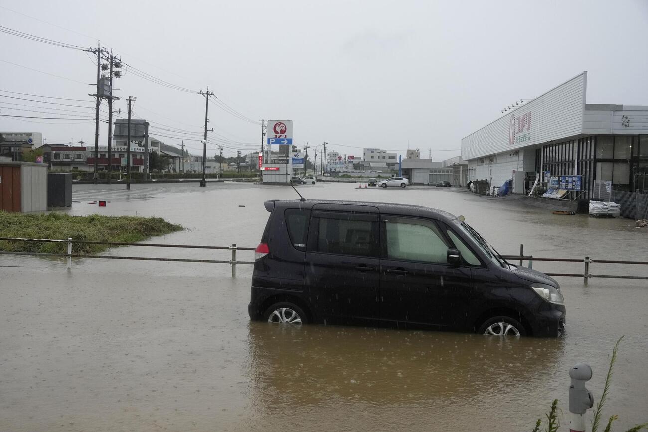 富山県氷見市にて、大雨の影響で冠水した道路に残された車両（共同）