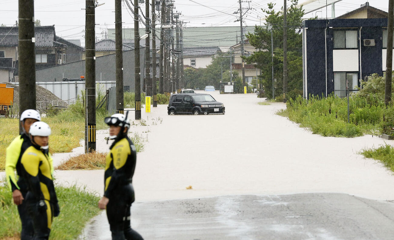 大雨で冠水し、車両が残された石川県羽咋市の道路（共同）