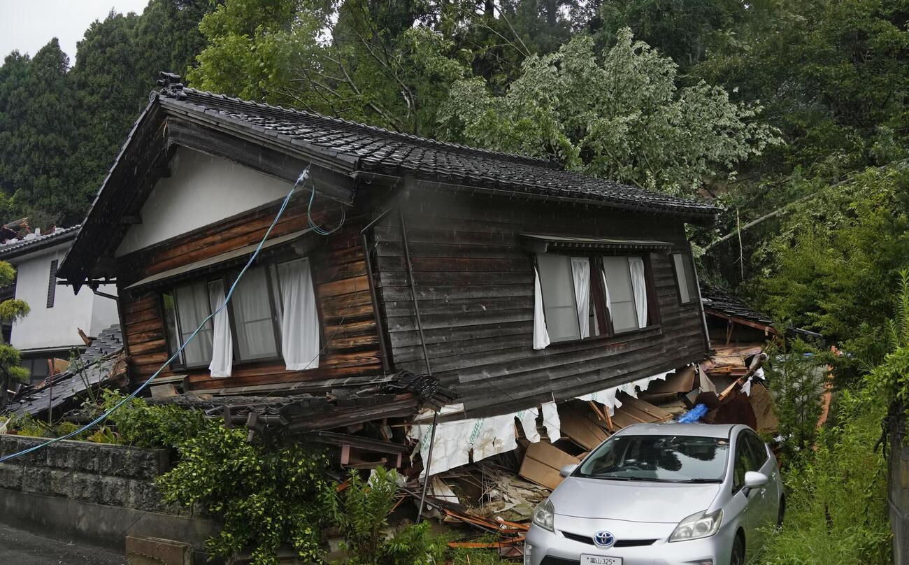 崩れた家屋。大雨の影響によるとみられる（共同）