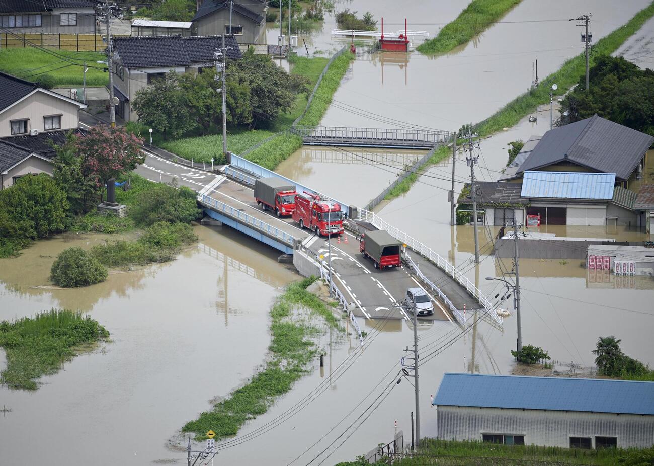 大雨の影響で冠水した富山県氷見市内の道路。中央は万尾川＝28日午前11時56分（共同通信社ヘリから）