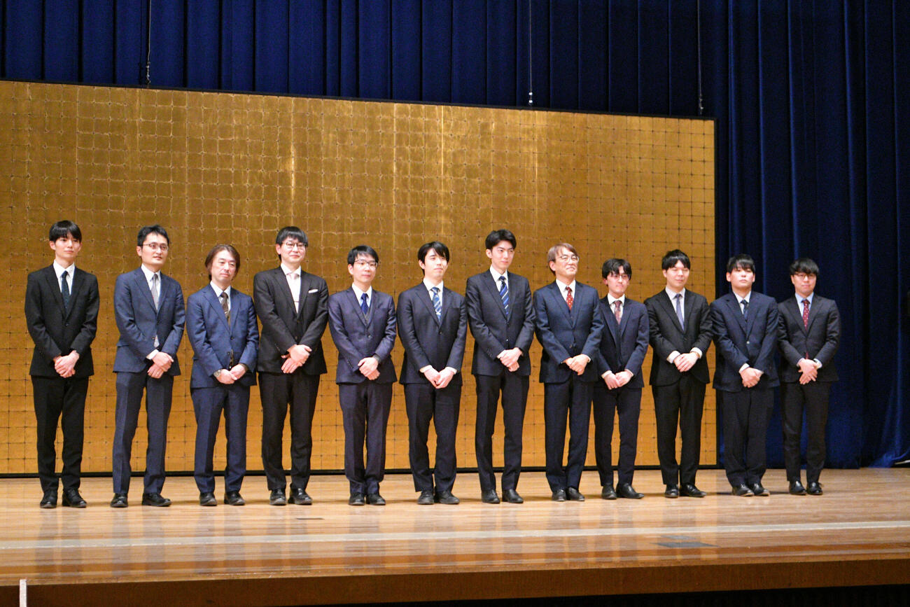 「SUNTORY　将棋オールスター東西対抗戦2025」の前日会見に出席した西軍の上野裕寿五段、稲葉陽八段、久保利明九段、山崎隆之九段、豊島将之九段、藤井聡太6冠と東軍の中村太地八段、羽生善治九段、伊藤匠叡王・王座、高見泰地七段、長谷部浩平五段、宮嶋健太四段（左から）（2025年12月撮影）