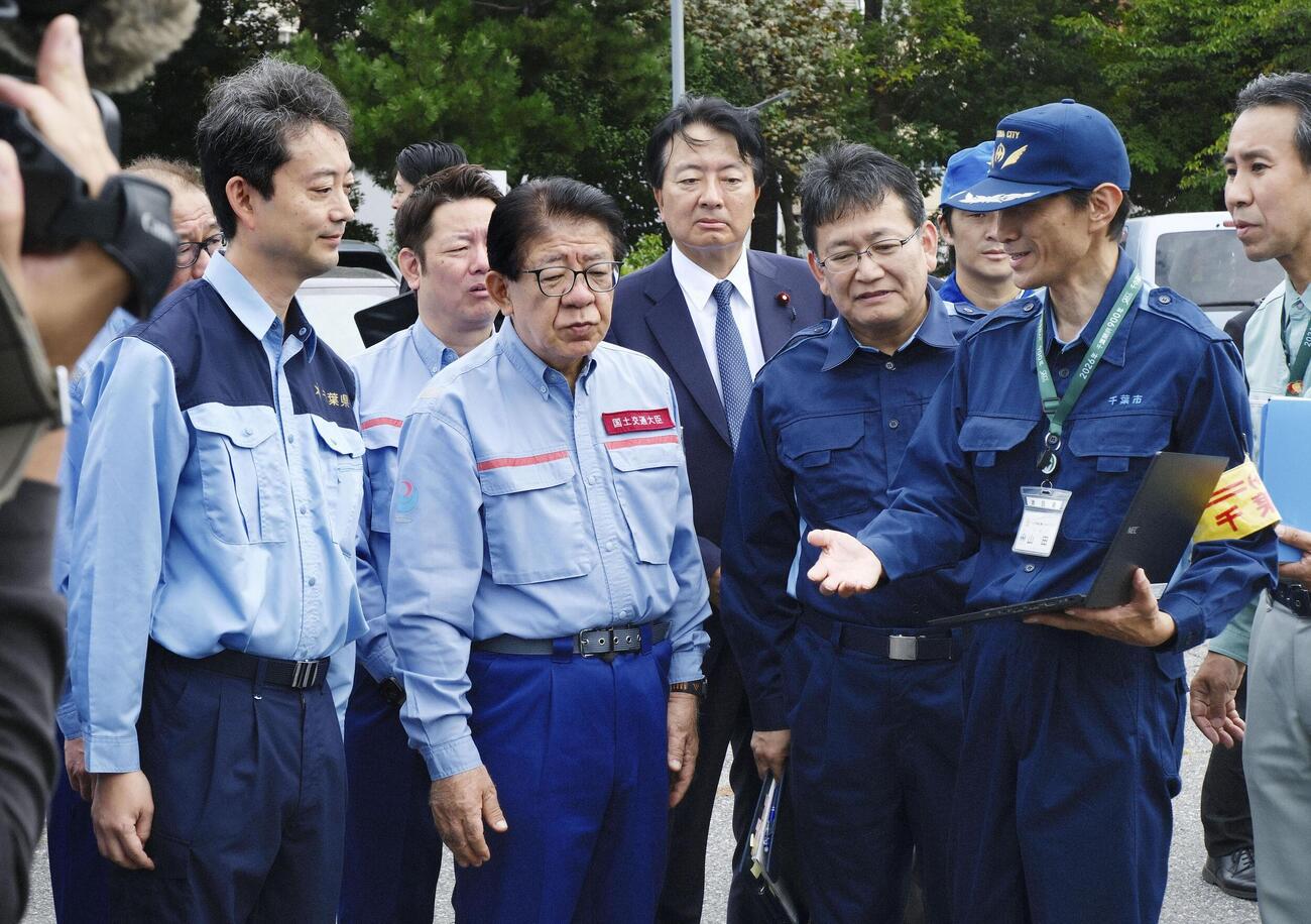 千葉豪雨で動かなくなり撤去された車両の仮置き場を視察する金子国交相（手前左から2人目）（共同）