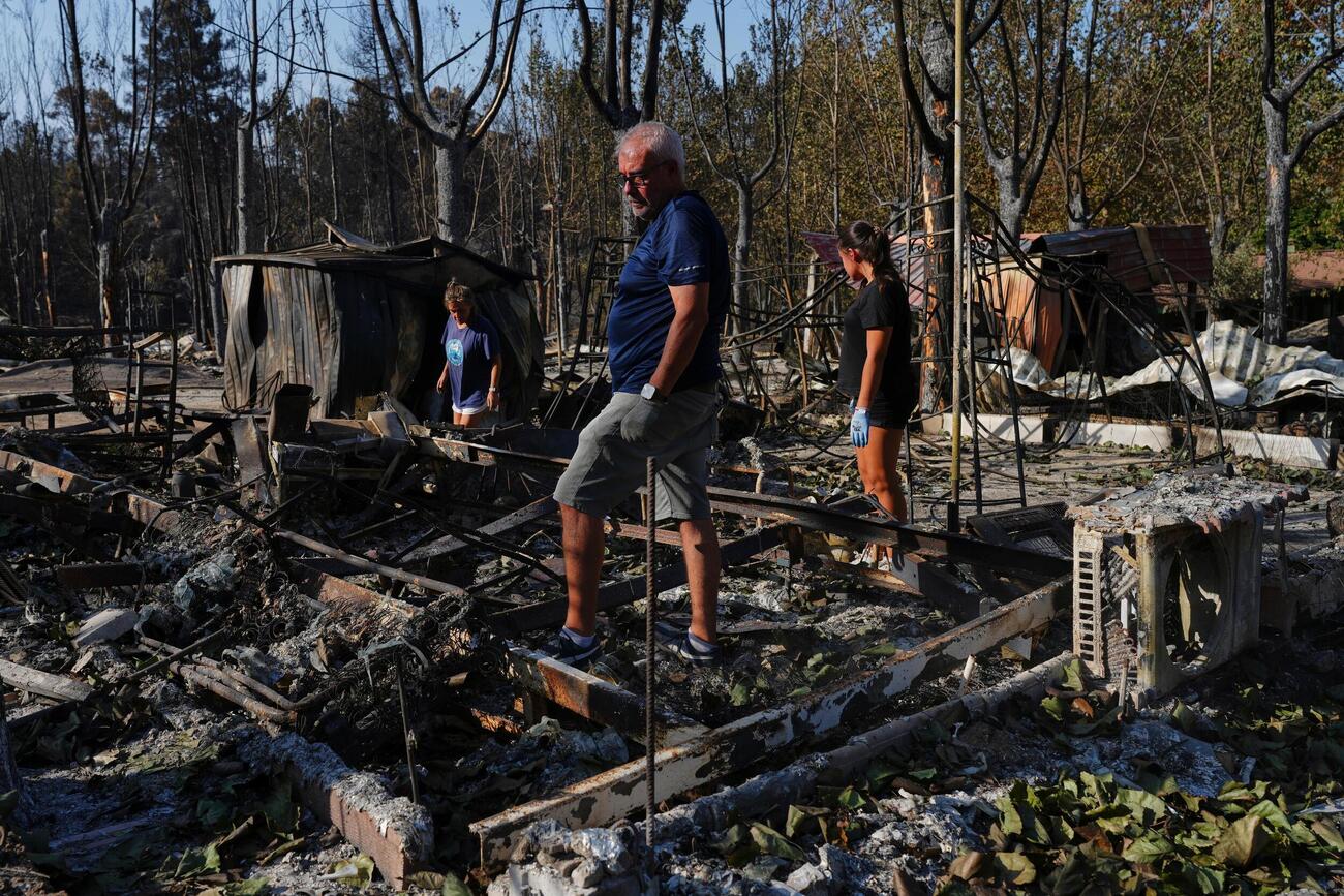 スペイン・マドリード近郊の山火事で、焼けたキャンプ場から持ち物を探す人たち＝7月（AP＝共同）