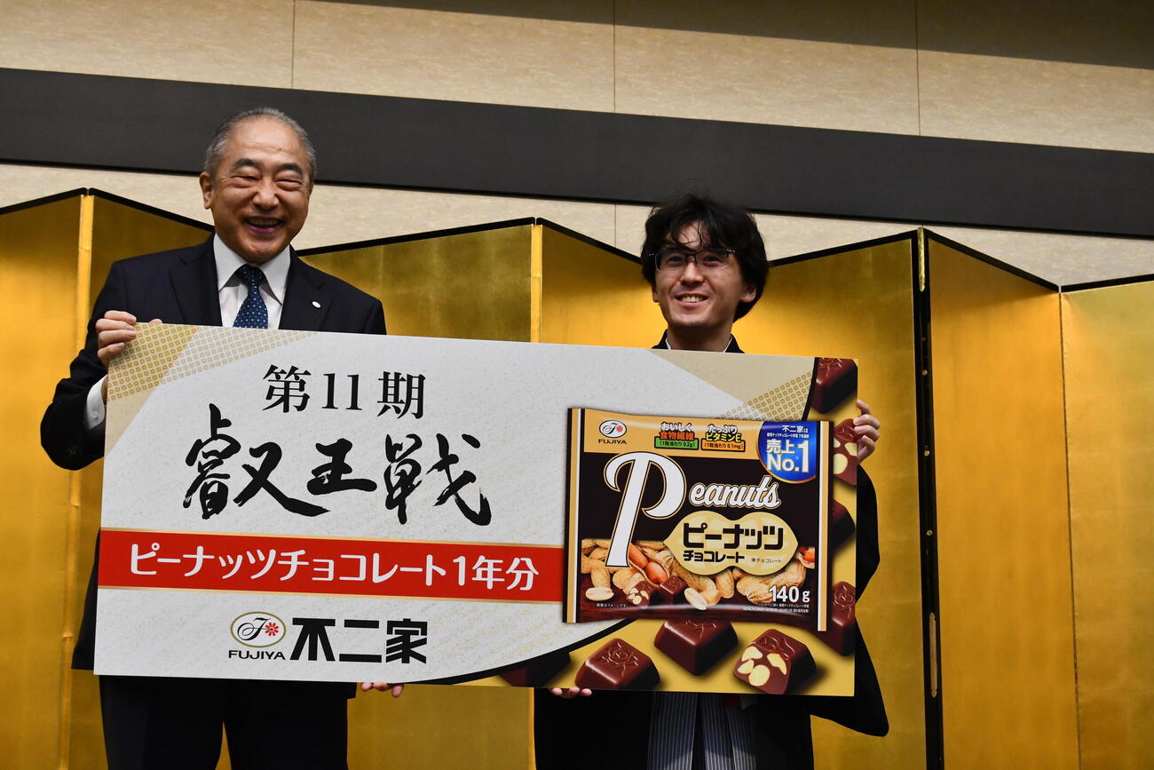 不二家の河村宣行社長（左）から副賞としてピーナッツチョコレート1年分が贈られた伊藤匠叡王