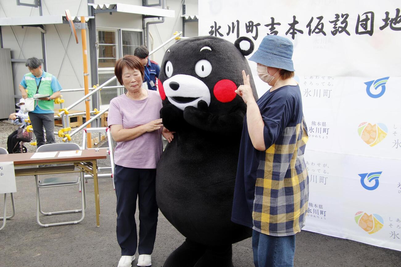熊本県氷川町に完成した仮設住宅で「くまモン」と記念撮影する入居者＝5日午前（共同）
