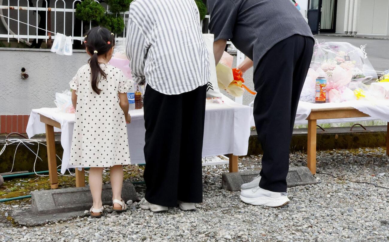現場となった園の駐車場で献花する河本千奈ちゃんの遺族（共同）