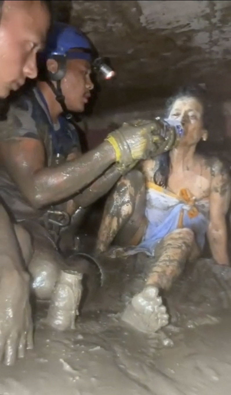 5日に公開された動画で、被災した民家から救助された女性に水を飲ませる救助隊員＝ネパール中部ヌワコト郡（首相府提供・ロイター＝共同）