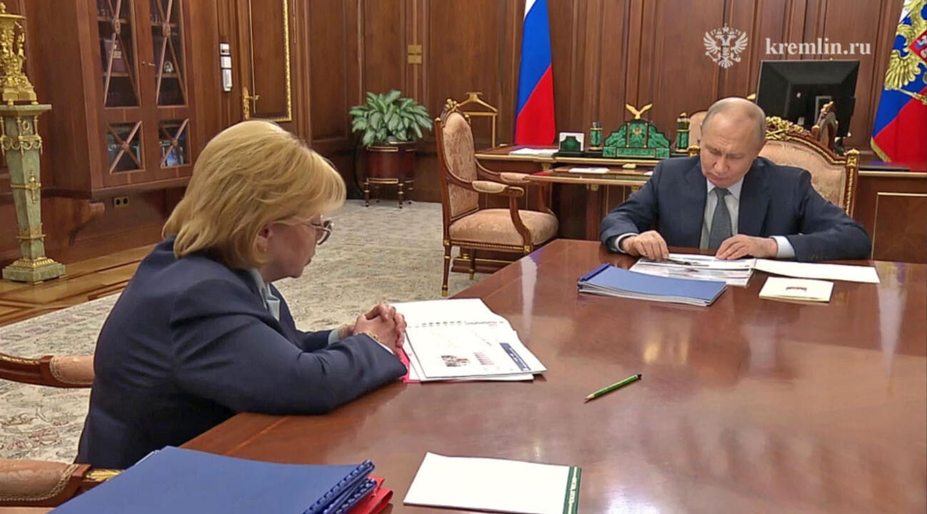 ロシア連邦医療生物学庁のスクボルツォワ長官（左）と会談した際、書類の上でペンを回すプーチン大統領＝8月27日、モスクワ（大統領府の動画から・共同）
