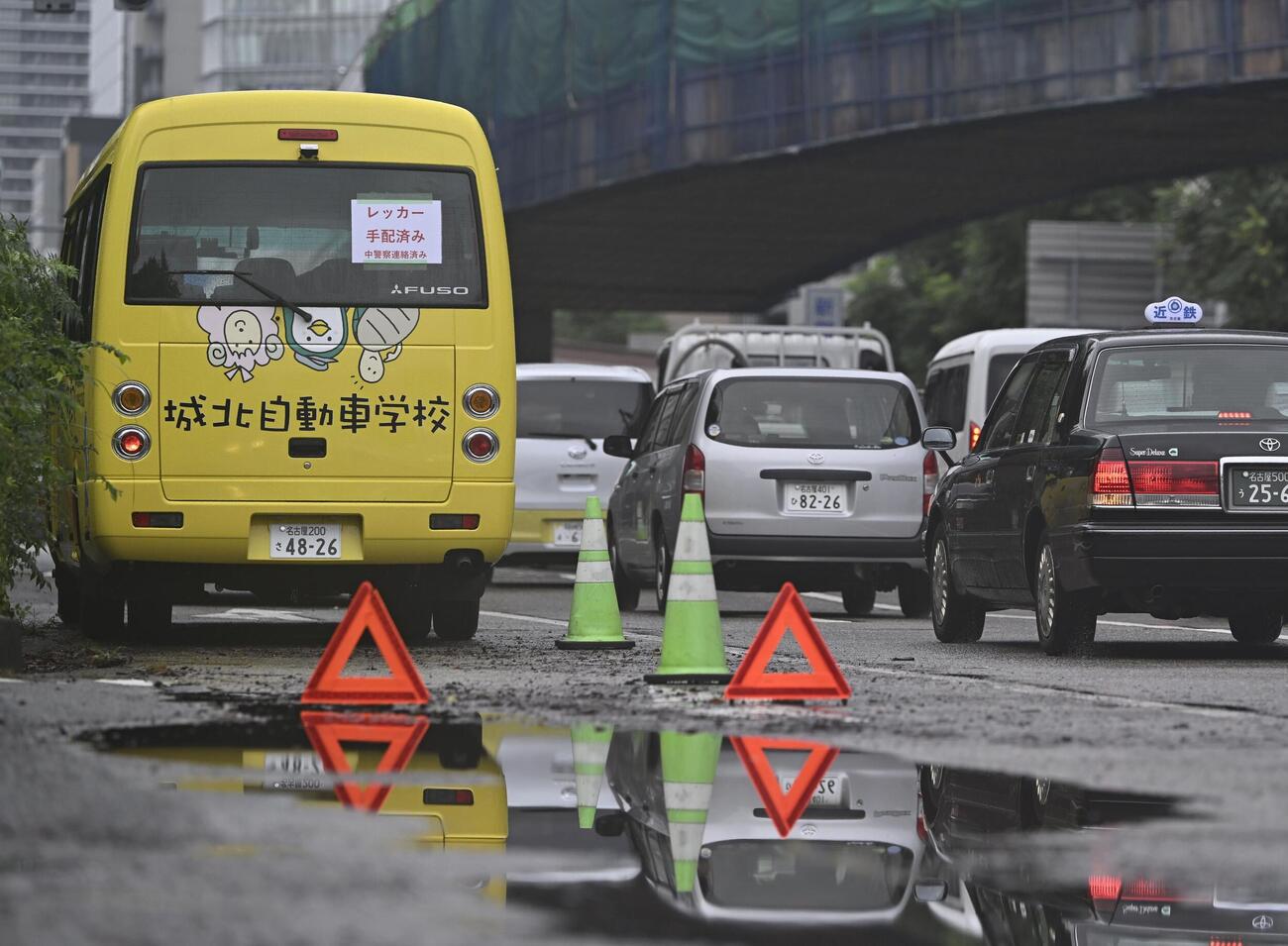 大雨で被災した車両が残る道路＝9日午前7時53分、名古屋市中区（共同）