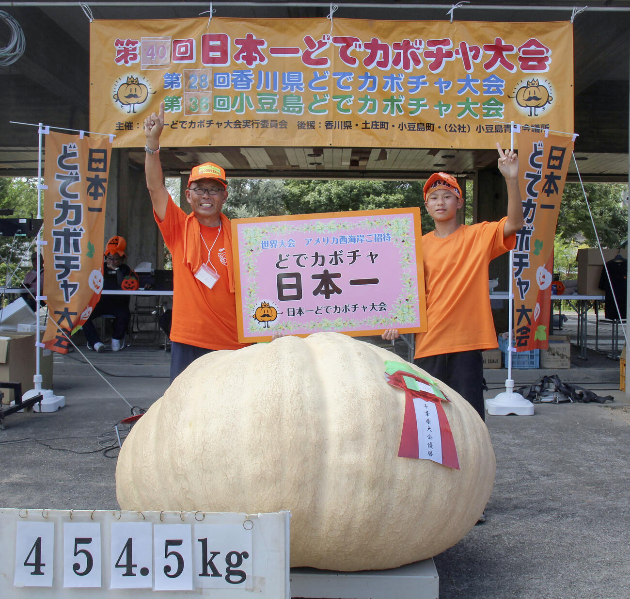 「日本一どでカボチャ大会」で優勝した田辺憲明さん（左）と3位に入った孫の響人さん（共同）