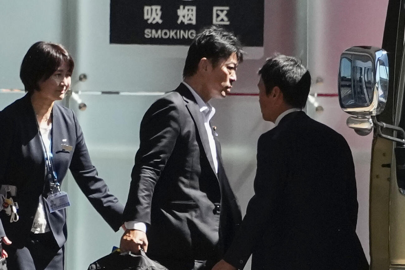 北京の空港に到着した日中友好議員連盟の高村正大・前法務副大臣（中央）＝13日（共同）